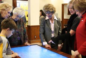 People gathered around an interactive smart screen at Customs House Museum