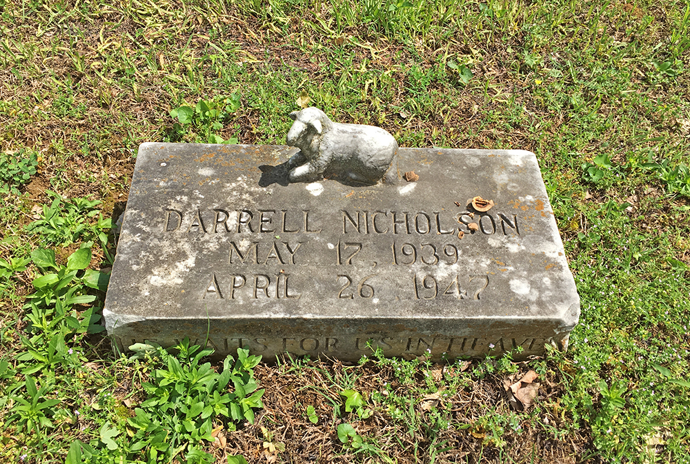 Headstone with an ornate lamb on it. Headstone reads 'Darrell Nicholson, May 17, 1939 - April 26, 1947.
