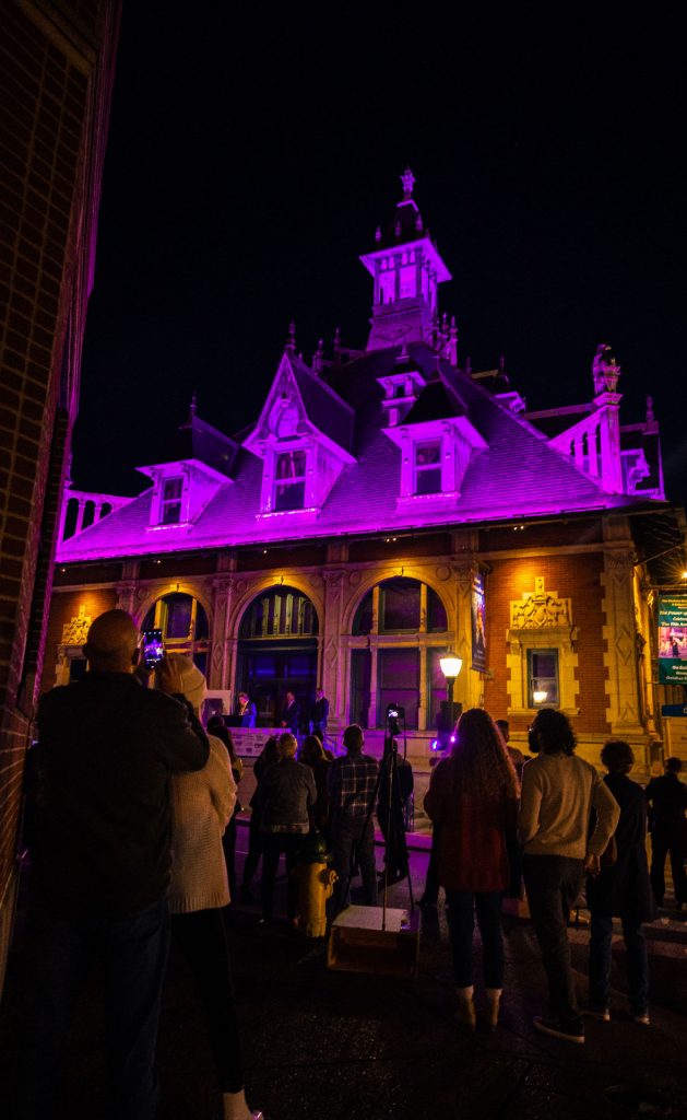The Customs House Museum & Cultural Center illuminated in purple for the crowd.