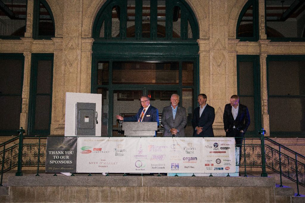 Executive Director Frank Lott stands on steps of the Museum along with sponsor representatives to turn on the roof lights.