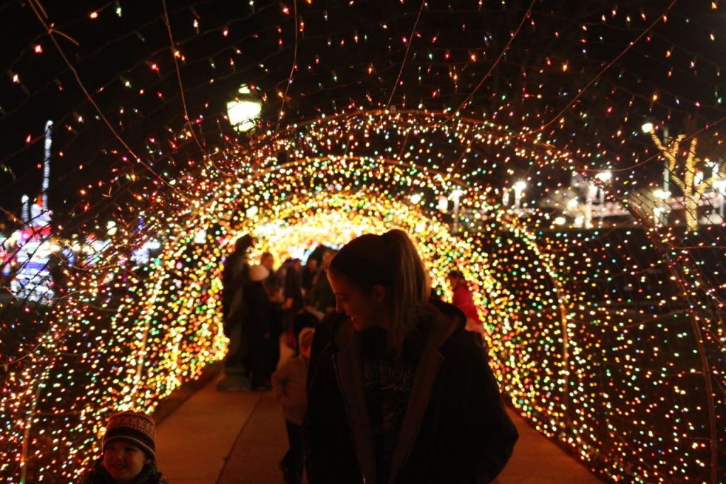 Nighttime scene of families under light arch at Christmas in Cumberland