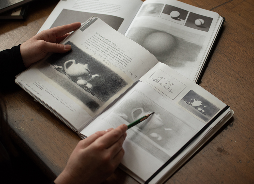 Juliette pointing to a page in her Classical Drawing Atelier:  A Contemporary Guide to Traditional Studio Practice book