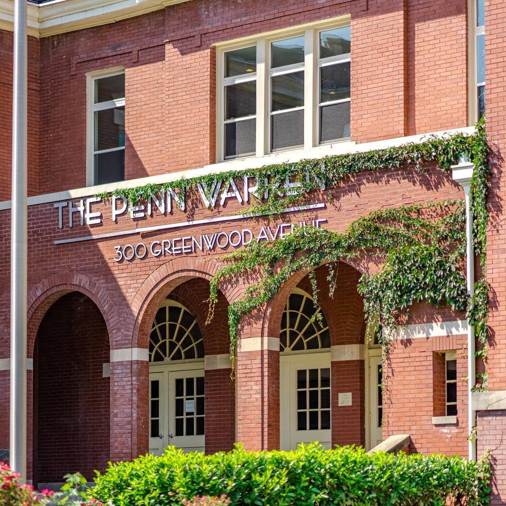 Entry way to the Penn Warren apartments. Brick building with greenery.