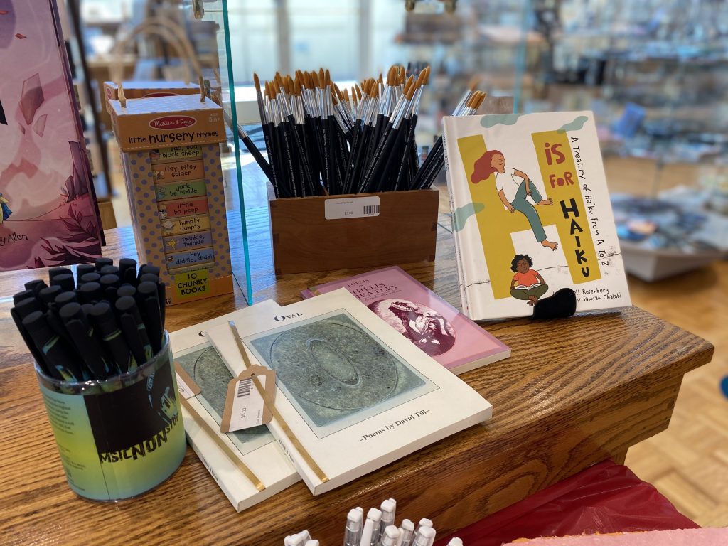 Gift shop display of pens, notebooks and books.