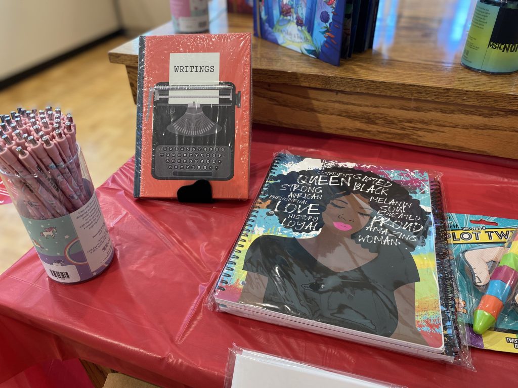 Gift shop display of pens, notebooks and books.