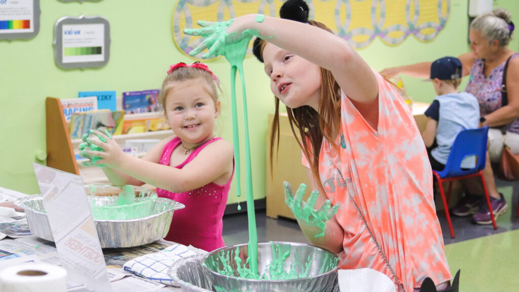 Photo of two girls making green slime in the Family Art Studio